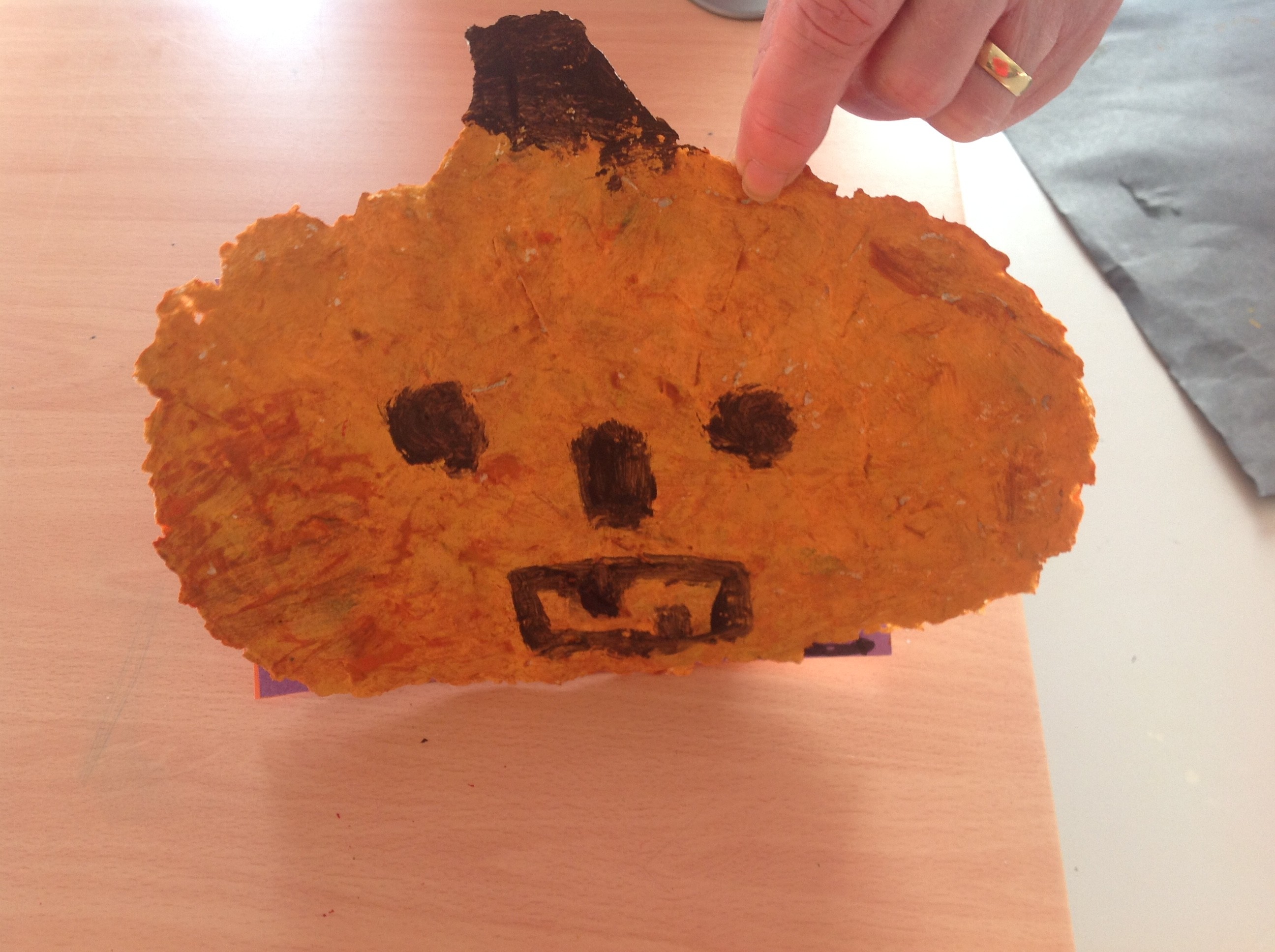 Pumpkin with facial features made with pulp paper. Paper mache pumpkin.